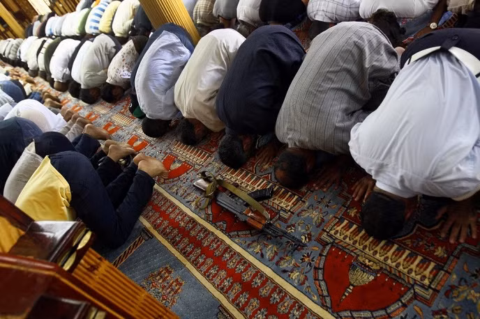 Khẩu AK được đặt trước người sở hữu nó trong buổi cầu nguyện ở nhà thờ Hồi giáo nasser Abd, Libya năm 2011.