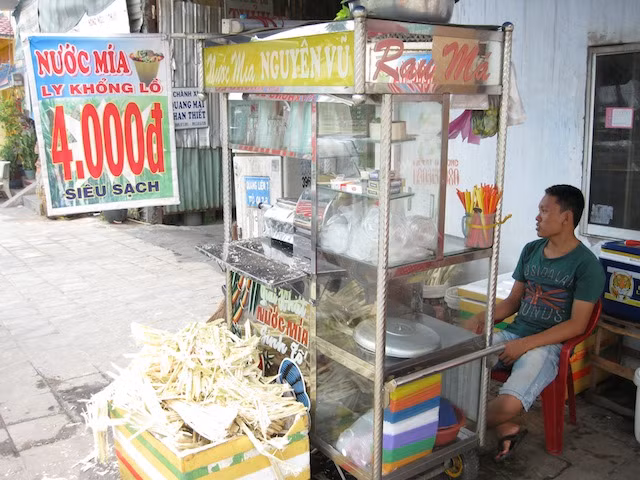 "Sau vài ngày ở Sài Gòn, chúng tôi phóng xe máy xuống hướng Nam, về phía đồng bằng sông Cửu Long. Hôm nay tôi chưa uống cốc nước mía nào, vì vậy chúng tôi dừng xe khi tôi phát hiện ra một quầy nước bía bên đường". Ảnh: Kayoko Akabori.