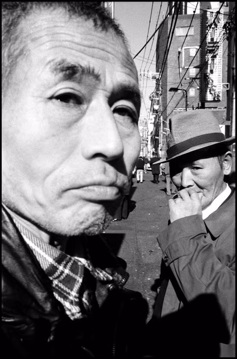 Hai "hướng dẫn viên" bên ngoài một tụ điểm đánh bạc ở thành phố Asakura. Hoạt động cờ bạc là nguồn thu quan trọng của các tổ chức Yakuza Nhật Bản. Ảnh: Bruce Gilden/ Magnum Photos.