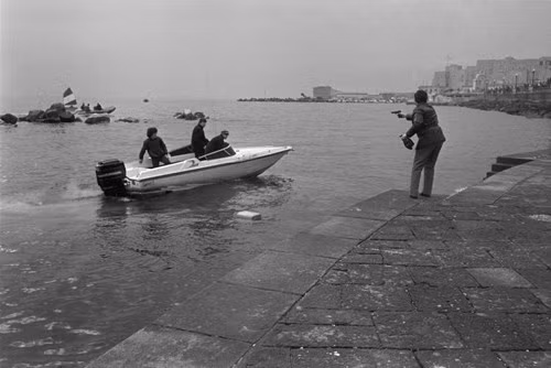 Một viên cảnh sát chĩa súng đe dọa những kẻ buôn lậu thuốc lá bằng đường biển. Những tên này đã thoát sau đó. Ảnh: Patrick Zachmann/ Magnum Photos.