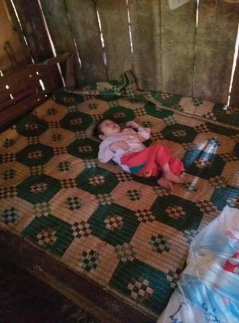 Bé Hoàng Thị Tâm nhỏ thó trên chiếc giường đơn sơ.