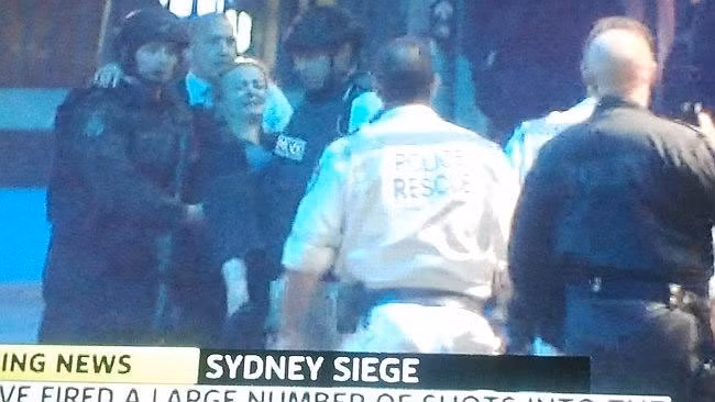 Cảnh sát khiêng một con tin bị thương ra khỏi hiện trường.