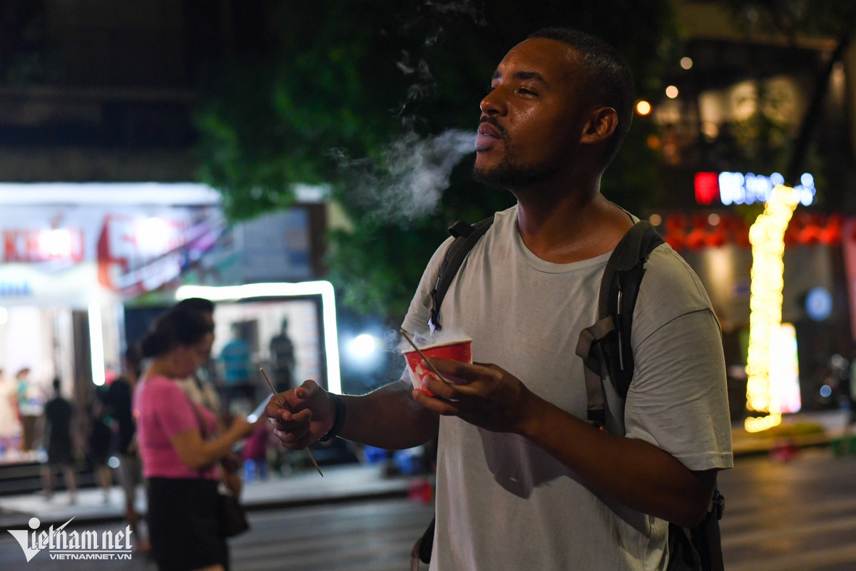 Travis thưởng thức món kem khói độc lạ ngay trên phố đi bộ. Anh sẽ có chuyến đi 21 ngày qua 3 nước Việt Nam, Thái Lan và Campuchia để bù lại những ngày "xiềng xích tại nhà" vì đại dịch Covid-19.