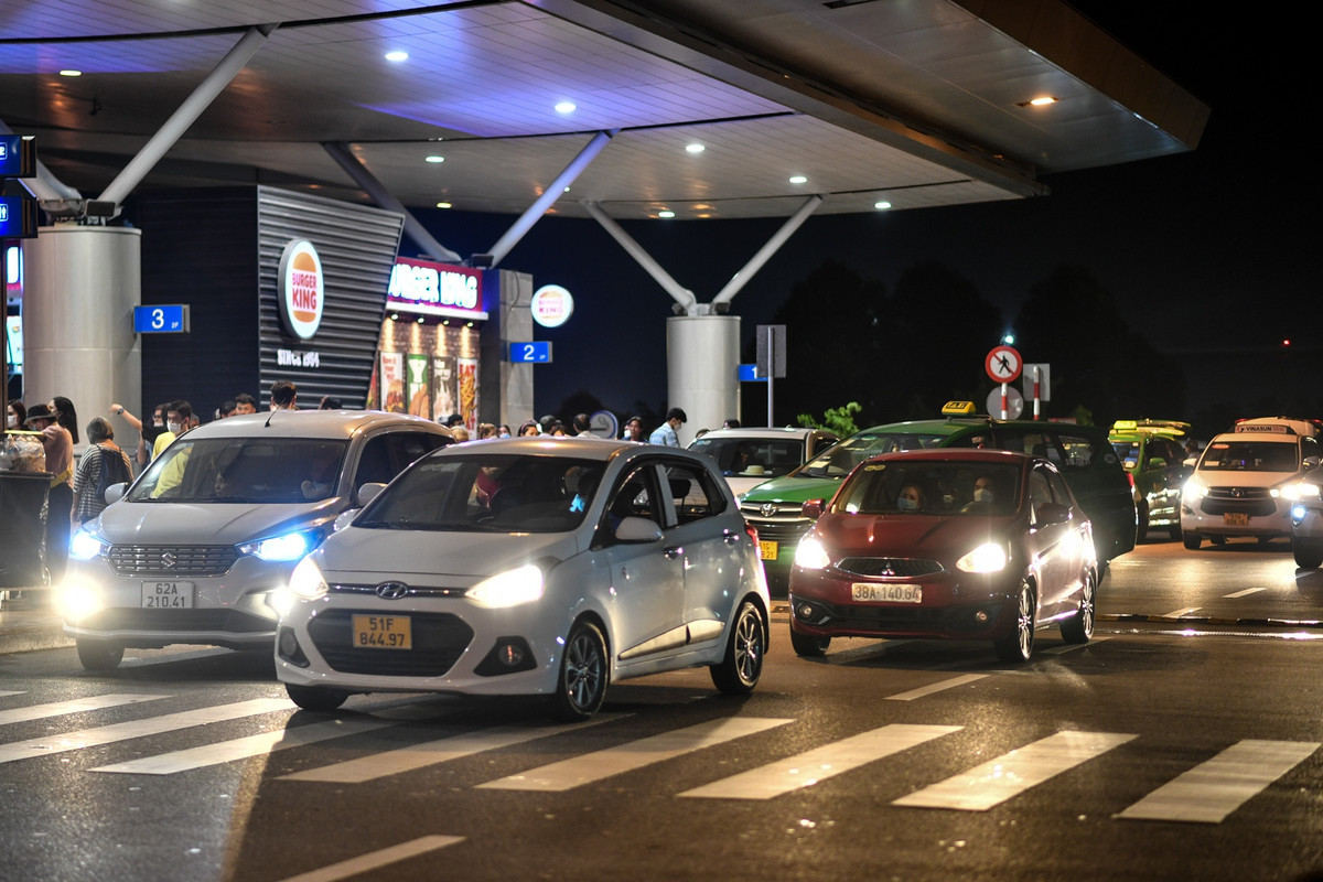 Các làn xe dẫn lên ga quốc tế nhộn nhịp, xe ôtô nối đuôi nhau trả khách trước cổng nhà ga đi.