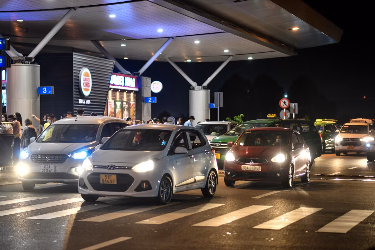 Các làn xe dẫn lên ga quốc tế nhộn nhịp, xe ôtô nối đuôi nhau trả khách trước cổng nhà ga đi.