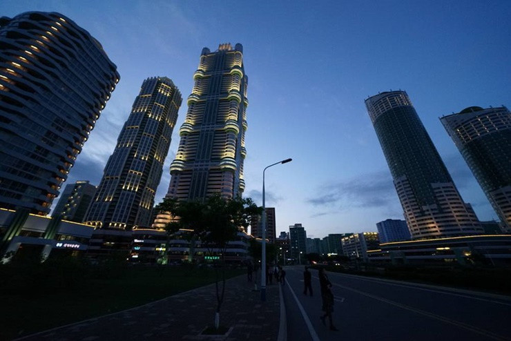 Khung cảnh nhìn của phố Ryomyong với con đường được trải nhựa phẳng, đẹp, hai bên được trồng cây quy củ.