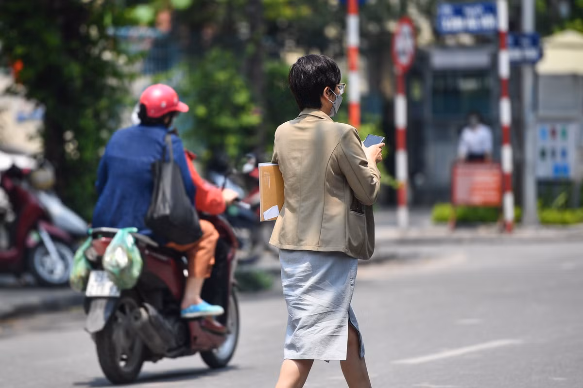 Một số người trở ra từ tòa nhà, trên tay cầm theo tập hồ sơ.