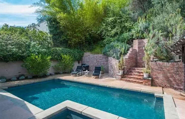 Nằm giữa một hồ bơi lấp lánh với sân lớn có mái che và những khu vườn bậc thang, còn có một bồn tắm nước nóng nằm trong khu vực lát đá phía trên.