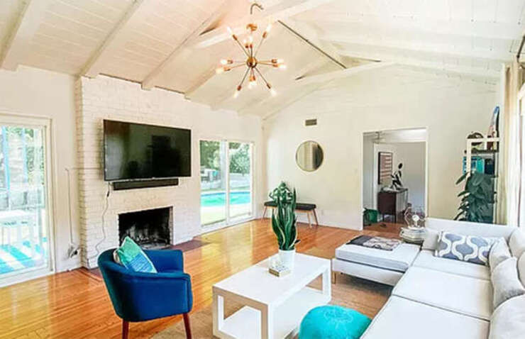 Khác xa với một dinh thự xa hoa của người nổi tiếng, ngôi nhà hai phòng ngủ, một phòng tắm có phòng khách với hai cửa kính đôi, trần nhà có xà ngang truyền thống và một lò sưởi ấm cúng đặt trên ống khói gạch quét vôi trắng.