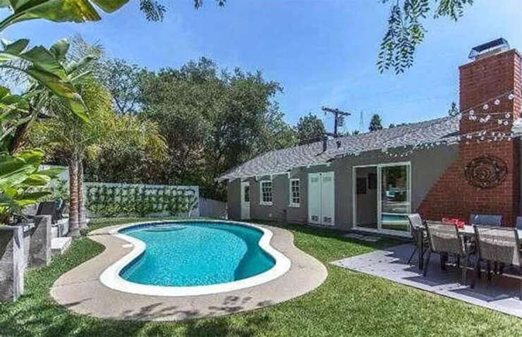 Dù là một căn nhà có diện tích khiêm tốn, nhưng Page vẫn thiết kế một bể bơi dễ thương. Khoảng sân xanh mát còn có một khu vực ăn uống ngoài trời, với một chuỗi đèn dây treo phía trên - hoàn hảo cho những bữa tối thư thái và những ngày hè nóng nực.