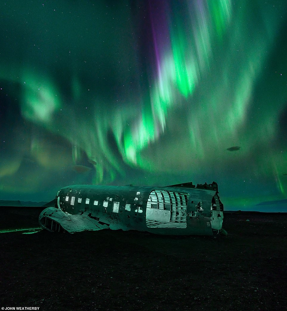 Hiện tượng cực quang tạo nên một màn trình diễn ánh sáng ngoạn mục trên bầu trời đêm ở Solheimasandur, Iceland. Bức ảnh của John Weatherby.