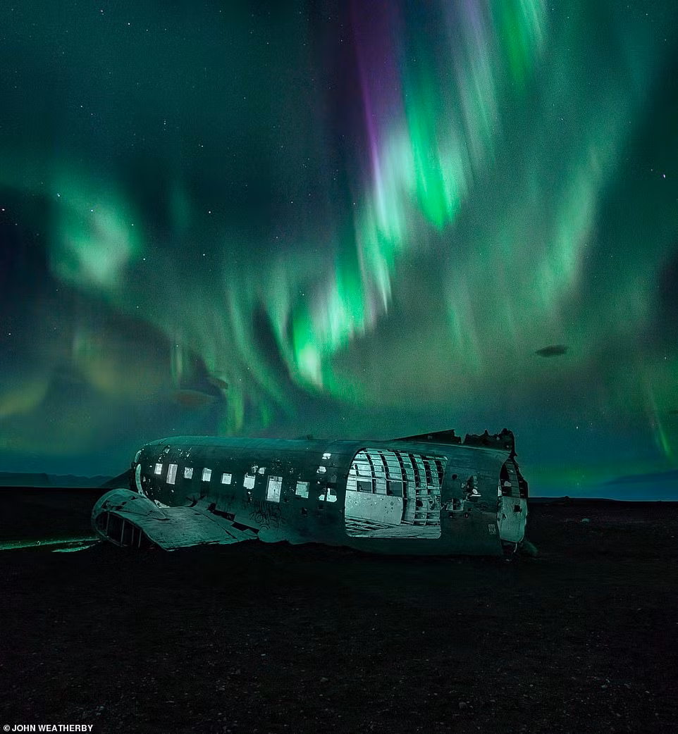 Hiện tượng cực quang tạo nên một màn trình diễn ánh sáng ngoạn mục trên bầu trời đêm ở Solheimasandur, Iceland. Bức ảnh của John Weatherby.