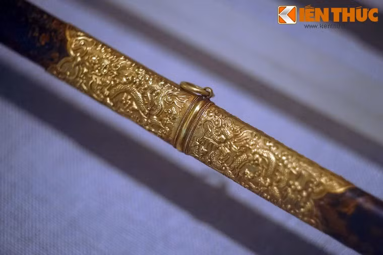 Phần bọc vàng trên vỏ của An dân bảo kiếm. Con rồng, ẩn dụ về một đấng Thiên tử (con của Trời) - là hình tượng xuyên suốt trong các hiện vật mang tính biểu trưng quyền lực.