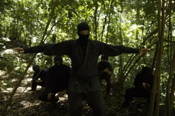 Các học viên chăm chú theo dõi người huấn luyện trình diễn các kỹ năng ninja.