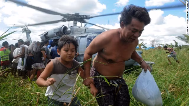 Nạn nhân của siêu bão Haiyan ở Philippines hối hả xếp hàng nhận viện trợ nhân đạo do trực thăng đưa tới.