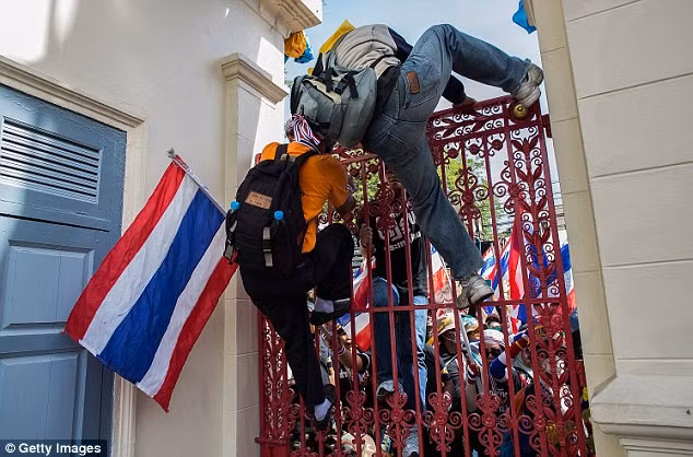 Nhiều người biểu tình không ngại nguy hiểm, liều mình trèo qua cổng để xâm nhập vào trụ sở của quân đội.