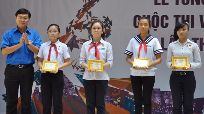 Em Phạm Thùy Linh (đứng giữa) cùng các học sinh có bài dự thi xuất sắc, nhận giải thưởng cuộc thi viết thư quốc tế UPU lần thứ 43. Ảnh: TTO.