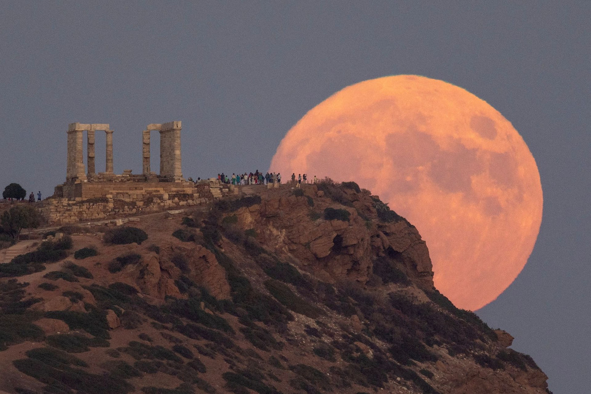 Trăng xanh mọc phía sau Đền Poseidon, ở Cape Sounion, gần Athens, Hy Lạp, ngày 30/8. Ảnh: Reuters. 