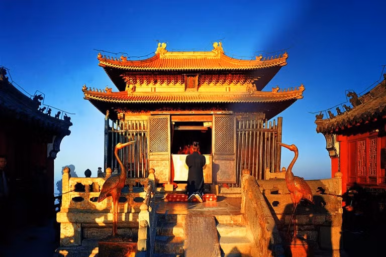 Tọa lạc trên đỉnh cao nhất của núi Võ Đang (1.612 m) là Trúc Kim Điện, biểu tượng của núi Võ Đang, được xây dựng vào năm 1416. Trúc Kim Điện được làm bằng đồng mạ vàng, nặng đến 405 tấn. Trải qua các triều đại, ngôi đền vẫn toát lên vẻ cổ kính, trầm mặc, lộng lẫy. Ngoài ra, trên núi còn có Thái Hòa Điện - khu đền thờ khổng lồ với mái ngói xanh liền kề nhau. Hoàng đế Vĩnh Lạc đã xây dựng công trình này, mô phỏng theo kiến trúc cố cung ở Bắc Kinh. Ảnh: Chinadiscovery.