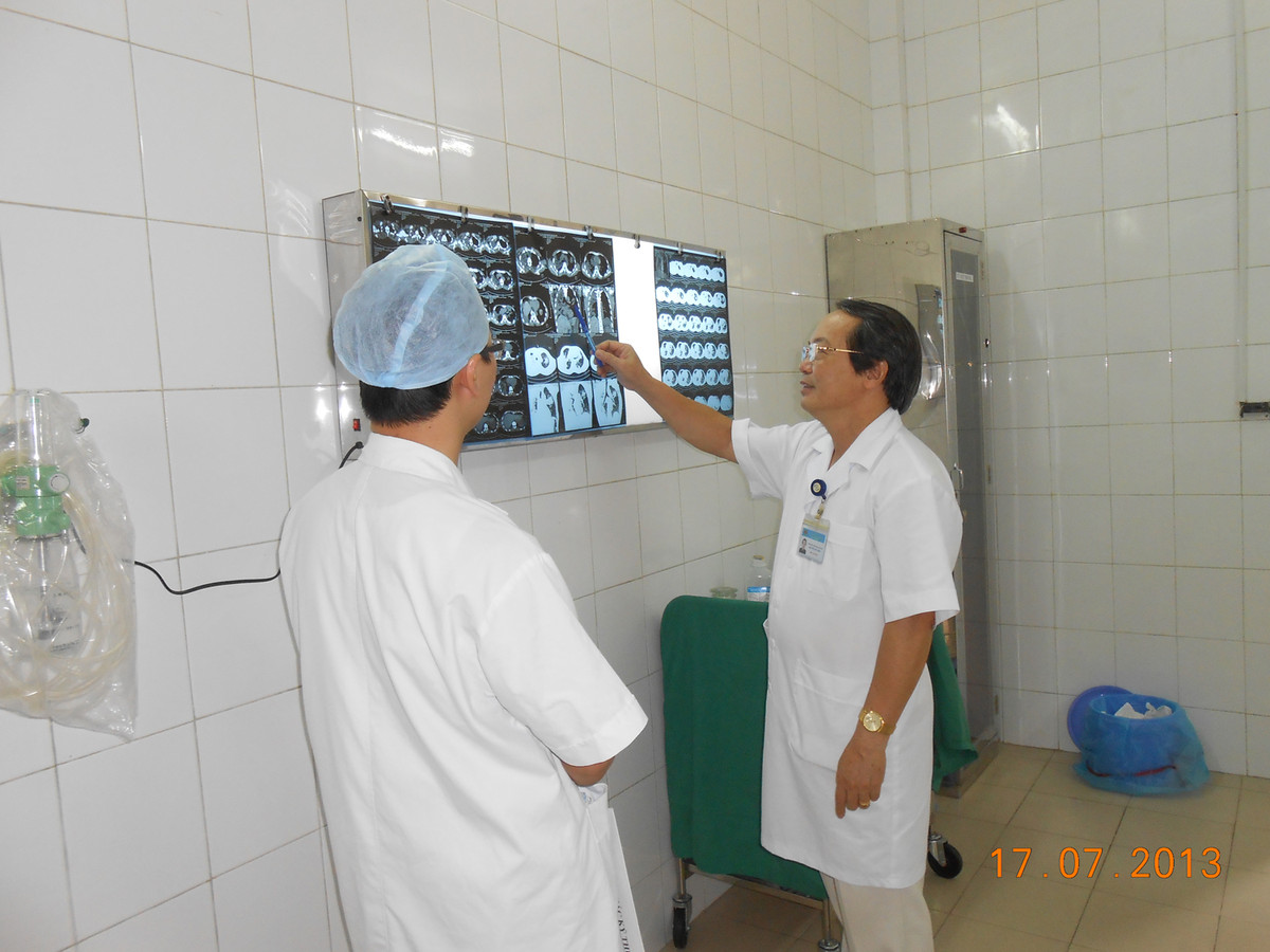 PGS.TS Nguyễn Chi Lăng chỉ cho nhân viên hình ảnh X-quang của bệnh nhân Thiện.