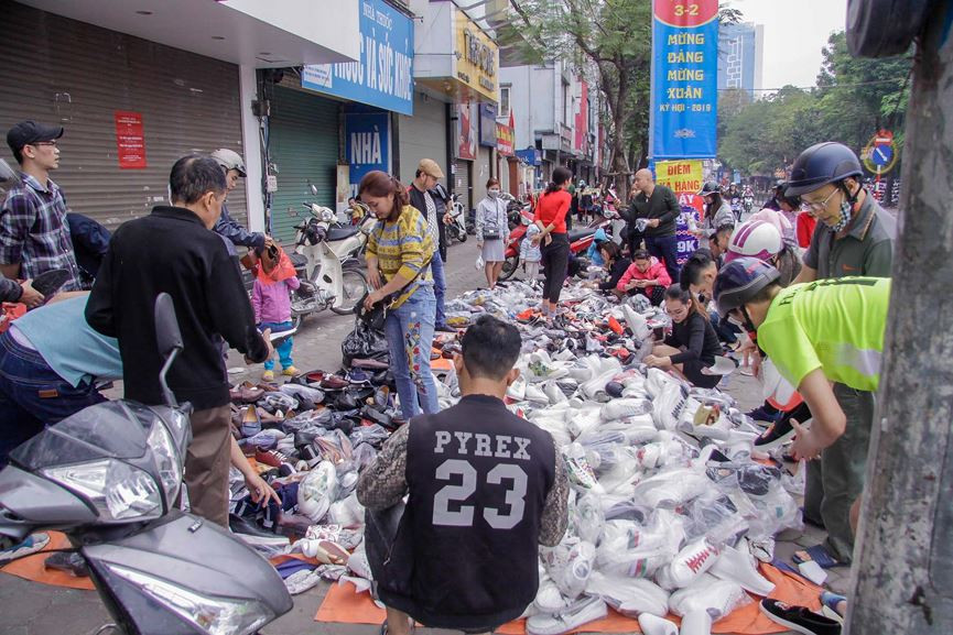Quần áo, giầy dép, túi xách... bày la liệt trên vỉa hè. Mỗi đôi giày ở đây bán chỉ từ 100.000đ/đôi.