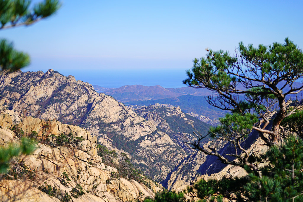 Từ đỉnh núi, du khách có thế phóng tầm mắt xa bốn phương, thu vào tầm mắt cảnh tượng vô vàn đỉnh núi nhấp nhô trùng điệp dưới ánh sáng mặt trời, lấp lánh như những viên kim cương. Đó chính là xuất xứ tên gọi núi Kim Cương.