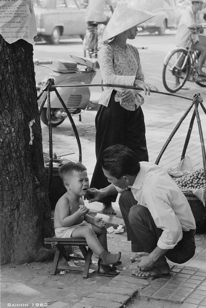 Ông bố kiểm tra hàm răng của đứa con đang mếu máo.