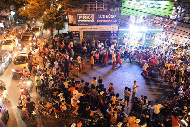 Rất đông người đi đường vây lại để xem màn biểu diễn múa lân.