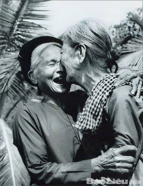  "Bắc Nam sum vầy. Bà mẹ miền Bắc (trái) và bà má miền Nam (phải) ôm nhau trong ngày toàn thắng. Bạc Liêu 1975". Bức ảnh ghi lại khoảnh khắc đẹp trong lịch sử của Việt Nam, khiến nhiều người xem vô cùng cảm động. Ảnh: Võ An Khánh. 