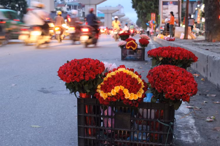 Vào khung giờ tan sở, các cô gái bày hẳn hoa xuống lòng đường để bán. Khi thấy ống kính PV, các cô gái bán hoa đã núp mặt ra phía sau gốc cây lớn, còn hoa để nguyên dưới lòng đường.
