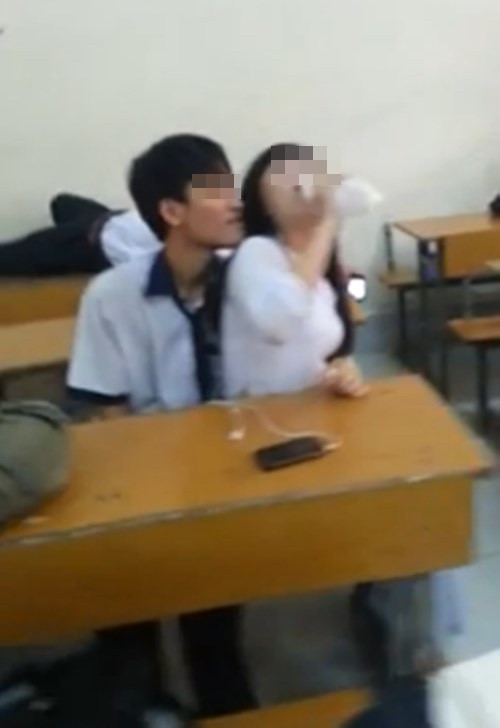 Đôi nam, nữ sinh có những hành động tình tứ trong lớp gây "nhức mắt". Ảnh cắt từ clip.