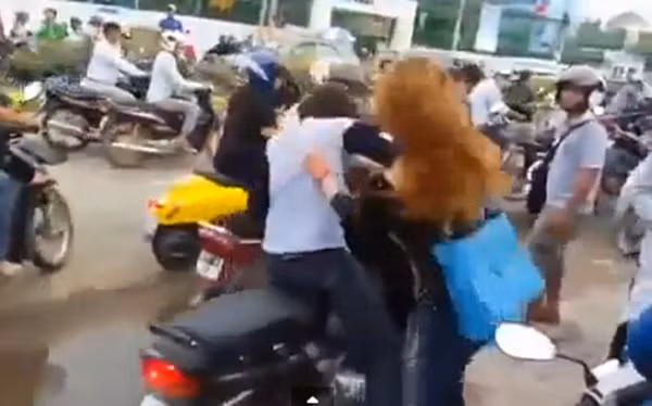 Nam thanh niên chưa kịp phóng xe đi, thì bị cô gái chạy lao tới tát liên tiếp lên đầu.