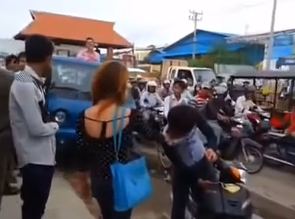 Hình ảnh cô gái lấy tay túm cổ áo nam thanh niên, khiến nhiều người đi đường hiếu kỳ dừng lại xem.