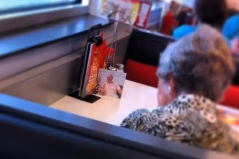 Dù người chồng đã qua đời nhưng người vợ vẫn mang theo tấm hình chồng bên cạnh, kể cả lúc ăn trưa