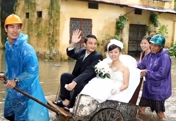 Một đôi bạn trẻ tổ chức đám cưới đúng trong trận lũ lịch sử năm 2008. Mặc dù cả đôi bạn trẻ phải ngồi trên xe cải tiến để "về dinh", nhưng chú rể vẫy tay chào, còn cô dâu luôn nở nụ cười hạnh phúc. (Đoạn đường Kim Liêm, Hà Nội).