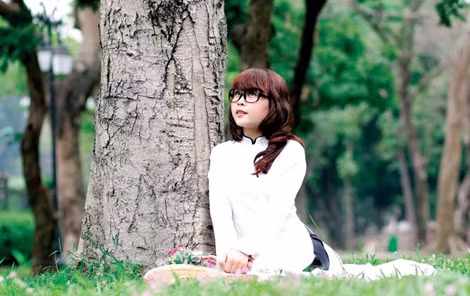 Nụ cười e ấp dưới hàng cây xanh