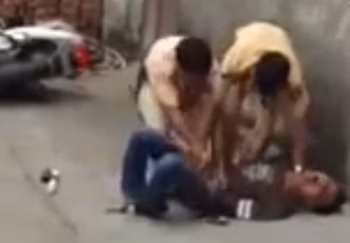 Hai CSGT vất vả khống chế nam thanh niên trong khi người này chống cự quyết liệt và không ngừng kêu la. Ảnh cắt từ clip.