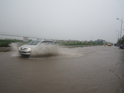 Do mưa lớn kéo dài, một số tuyến đường ngoại thành của Hà Nội cũng bị ngập bì bõm trong nước. (Ảnh chụp tại Km17, Quốc lộ 1A cũ, Quán Gánh, Hà Nội). 