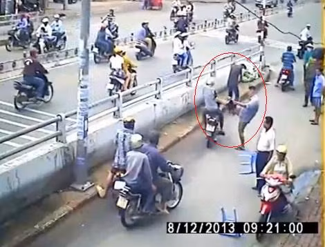 Quá tức giận nạn nhân còn lấy chân đạp tên trộm ngồi trên chiếc xe máy. (Ảnh cắt từ clip)