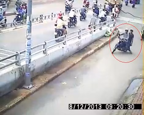 Hai kẻ trộm xuất hiện giữa chốn đông người (khoanh đỏ). (Ảnh cắt từ clip)