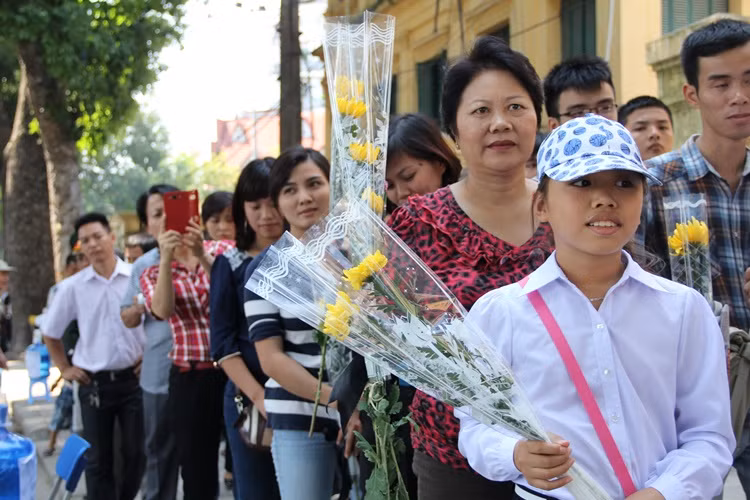 Em nhỏ cầm hoa, xếp thành hàng đợi đến lượt vào kính viếng "Cụ Giáp"