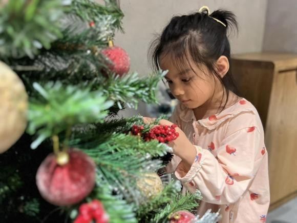 i nữ Tuệ An nhà Phạm Quỳnh Anh phụ mẹ trang trí cây thông Noel, trông vô cùng chăm chú.