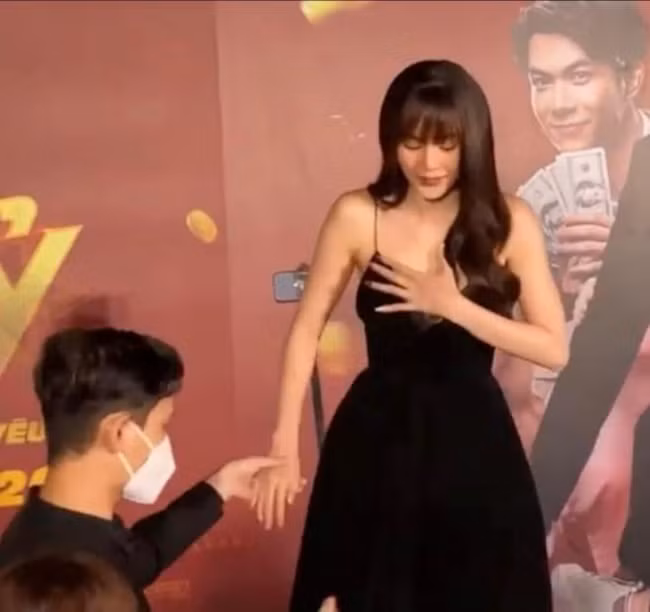 Ninh Dương Lan Ngọc phải dùng tay che chắn vòng 1 vì váy cổ chữ V trong một sự kiện mới đây.