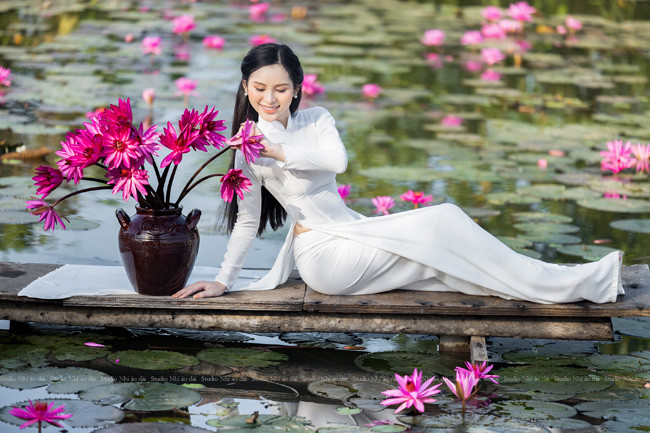 Mới đây, cô nàng vừa chia sẻ bộ ảnh diện áo dài, tạo dáng bên hoa súng, nhận được nhiều lời khen ngợi của người hâm mộ.