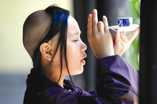 Kỳ lạ chú tiểu, một tay bưng chén nước nhỏ, một tay bắt ấn cam lồ - Ảnh minh họa.