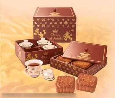 Vẫn là hộp bánh vuông truyền thống nhưng điều đặc biệt là nó có hai tầng, tầng dưới đựng những tách trà, chỉ cần thêm nước sôi là dùng được. Còn tầng trên là 4 chiếc bánh nướng thơm ngon, in hình chuột Mickey.