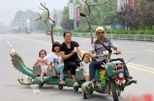 Người dân lái chiếc "xe chế mình rồng" đi dạo phố ở Chu Khẩu, tỉnh Hà Nam.