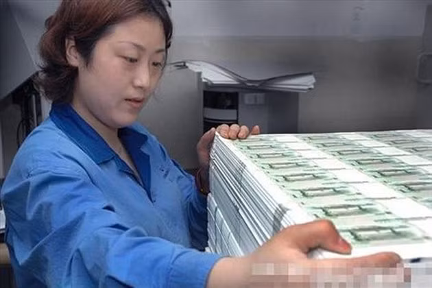 Nhân viên đang xếp tiền bên trong nhà máy in đồng NDT của Trung Quốc.