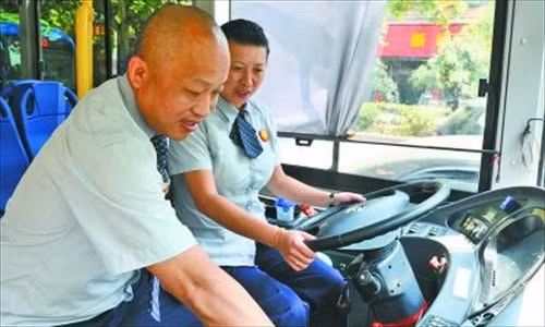 Dai Liqing (trái) và vợ Ren Yanli đổi ca trên tuyến xe buýt 719 ở thành phố Vũ Hán, tỉnh Hồ Bắc, Trung Quốc.