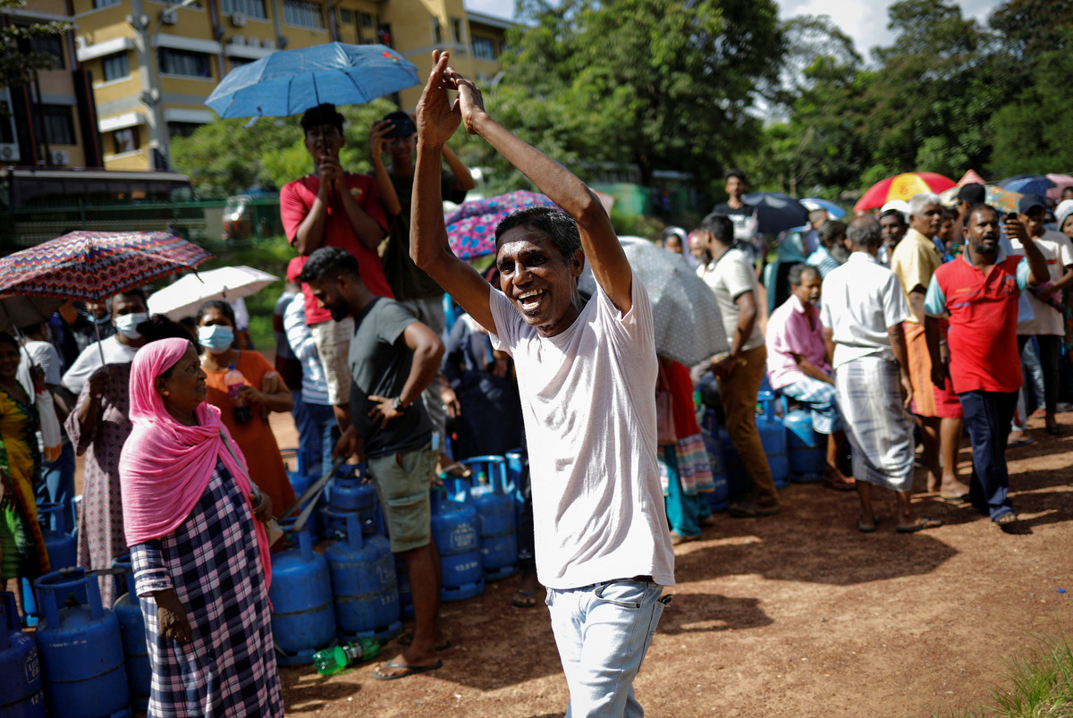 Một người đàn ông ăn mừng khi thấy chiếc xe tải chở khí đốt dùng để nấu ăn đến một điểm phân phối ở Colombo.